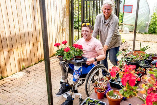 woman pushing a man in wheel chair